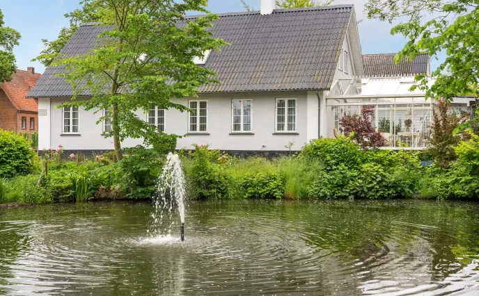 drivhus med have og springvand